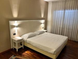 sypialnia z dużym białym łóżkiem i oknem w obiekcie Inn Rome Rooms & Suites w Rzymie