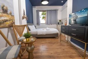 a bedroom with a bed and a table and a tv at GODSON TALPIOT in Haifa