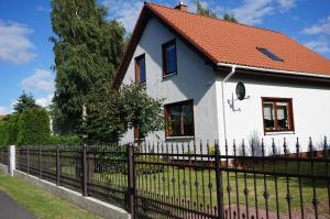 a white house with a fence at Ferienhaus für 4 Personen und 2 Kinder in Ustronie Morskie, Ostseeküste Polen in Ustronie Morskie