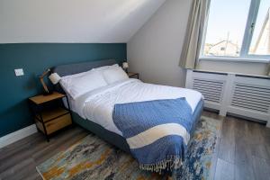 a bedroom with a bed with a blue wall at Port Aran House in Kilronan