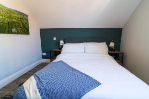 a bedroom with a large bed with a blue accent wall at Port Aran House in Kilronan +19 photos