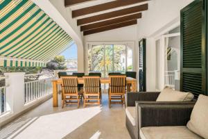 a living room with a table and chairs at Villa Arena in Es Mercadal