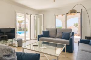 a living room with a couch and a glass table at Villa Mila in Sant Lluis