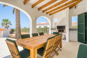 a dining room with a wooden table and chairs at Villa Mila in Sant Lluis