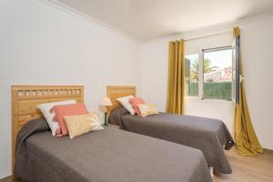 two beds in a room with a window at Villa Mila in Sant Lluis +34 photos