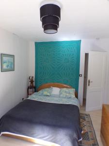 1 dormitorio con 1 cama con pared verde en L'ÉCHAPPÉE BELLE, en Rians