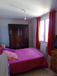 1 dormitorio con cama rosa y ventana en L'ÉCHAPPÉE BELLE, en Rians