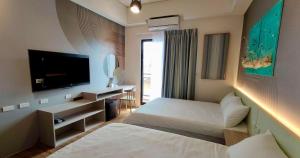 Habitación de hotel con cama y TV de pantalla plana. en Mi Hai B&B, en Magong