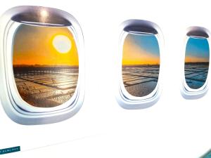 an airplane window with the sunset seen through it at Aveiro Central Its ALL there Apartment in Aveiro