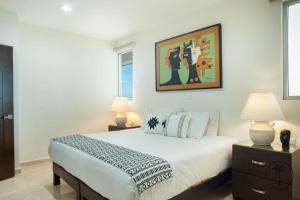 a bedroom with a large bed and two lamps at Spacious Apartment with Private Balcony & Ocean View - Brujas in Mazatlán