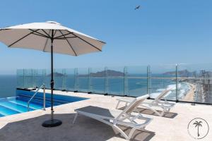 a pair of chairs and an umbrella next to a swimming pool at Vista a la Laguna y Amenidades Unicas in Mazatlán