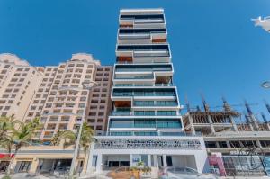 a tall building with palm trees in front of it at Vista a la Laguna y Amenidades Unicas in Mazatlán