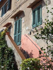 a building with green doors and stairs in front at Casa Marciana 2 - Isola D'Elba in Marciana