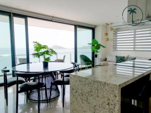 a living room with a table and some chairs at Moderno condominio con vista al mar! in Mazatlán