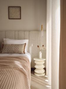 ein Schlafzimmer mit einem Bett und einer Vase auf dem Boden in der Unterkunft SOLEIL LUXURY VILLAS in Lithakia