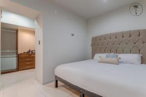 a bedroom with a large bed with a large headboard at ALFA - Dpto 2 hab en zona céntrica y cerca de la playa in Mazatlán