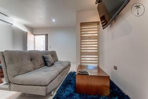 uma sala de estar com um sofá e uma mesa de centro em ALFA - Dpto 2 hab en zona céntrica y cerca de la playa em Mazatlán