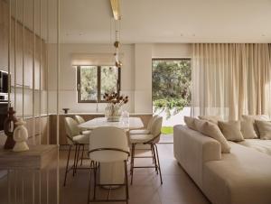 ein Wohnzimmer mit Sofa, Tisch und Stühlen in der Unterkunft SOLEIL LUXURY VILLAS in Lithakia