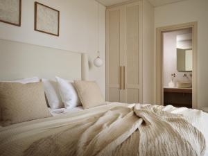 ein weißes Bett mit einer Decke in einem Schlafzimmer in der Unterkunft SOLEIL LUXURY VILLAS in Lithakia
