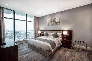 una camera con un grande letto e ampie finestre di فندق شراعوه الملكي - Luxury a Doha