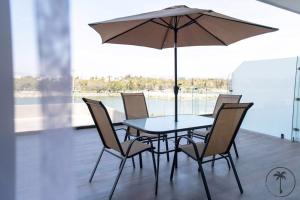 マサトランにあるHermosa terraza con vista a la laguna!のテーブルと椅子、バルコニー(パラソル付)