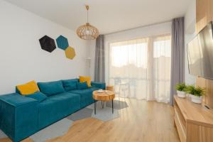 un soggiorno con divano blu e tavolo di Marynarska Modern Apartment with Parking by Renters a Sarbinowo