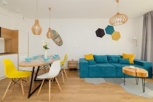 un soggiorno con divano blu e tavolo di Marynarska Modern Apartment with Parking by Renters a Sarbinowo