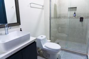 a bathroom with a toilet and a sink and a shower at Spacious family apartment in Mazatlán in Isla Venados +20 photos