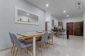 una cucina e una sala da pranzo con tavolo e sedie in legno di ISURUS - Dpto con bar, piscina y gimnasio a Mazatlán