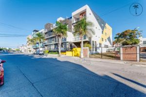 una strada vuota con un edificio e palme di ISURUS - Dpto con bar, piscina y gimnasio a Mazatlán