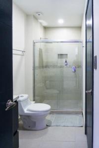a bathroom with a toilet and a glass shower at Spacious family apartment in Mazatlán in Isla Venados