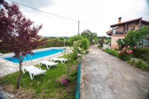 a house with a swimming pool and two white benches at CASA EL CARMEN 1 in Ciudad-Rodrigo