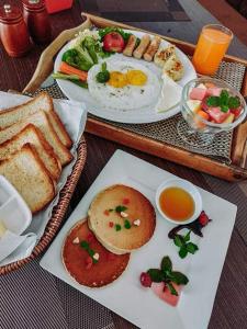 uma mesa com dois pratos de alimentos e bebidas para o pequeno-almoço em ROYAL VILLA RESORT em Catmandu