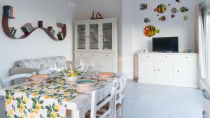 een witte eetkamer met een tafel met gerechten erop bij Welcomely - La Casa Sul Mare in Cala Liberotto