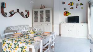 a white dining room with a table with dishes on it at La Casa Sul Mare in Cala Liberotto
