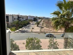 a balcony with a view of a street and palm trees at Appartement haut standing résidence Iken Parc Agadir Founty in Agadir