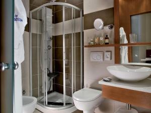 een badkamer met een douche, een toilet en een wastafel bij Color Alexandra Plaza Family Hotel in Riccione