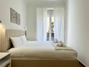 1 dormitorio con 1 cama blanca grande y ventana en Chueca Stylish Flat 2BD in the City Center+Balcony, en Madrid