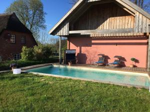 a house with a swimming pool in the yard at Hoheluft am Wittensee Apt 2 in Groß Wittensee