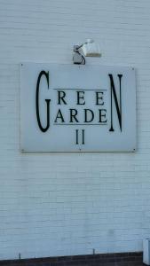 um sinal numa parede de tijolos brancos com um sinal para garagem verde em Charmante studio Nicky em Middelkerke