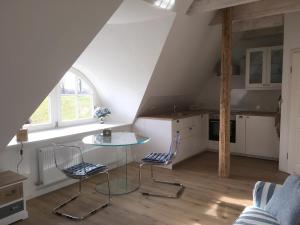 a kitchen with a glass table and two chairs at Hoheluft am Wittensee Apt 2 in Groß Wittensee