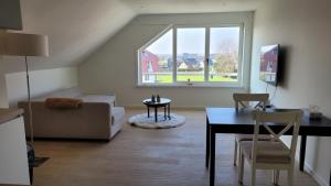uma sala de estar com um sofá, uma mesa e uma janela em Charmante studio Nicky em Middelkerke