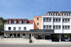 a large white building with a bilfer sign on it at Hotel Hiller in Abstatt in Abstatt