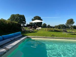 a swimming pool in a yard with a table at Hoheluft am Wittensee Apt 2 in Groß Wittensee