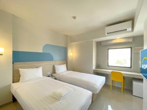 a hotel room with two beds and a window at Hop Inn Ayutthaya in Phra Nakhon Si Ayutthaya