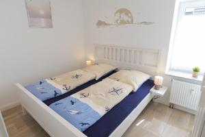 1 dormitorio con 1 cama con sábanas azules y blancas en FeWo Ultima Poel an der Ostsee - ABC367 - Nur an Feriengäste, en Kirchdorf
