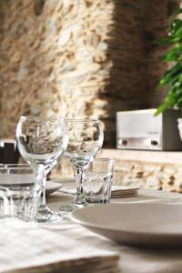 a table with wine glasses and a plate on it at Borgo del Canto in Borghetto dʼArroscia