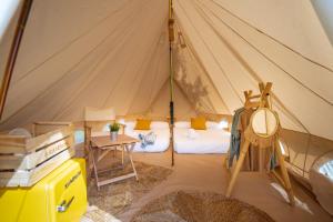 a room with a tent with a bed and a table at Kampaoh Ría de Arosa Playa in Pobra do Caramiñal