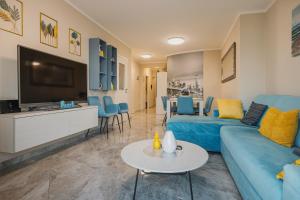 a living room with a blue couch and a tv at BLUEMARINE in Umag