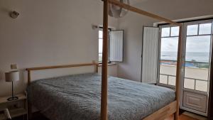 1 dormitorio con 1 cama y vistas al océano en Casa do Xixo, en Quiaios